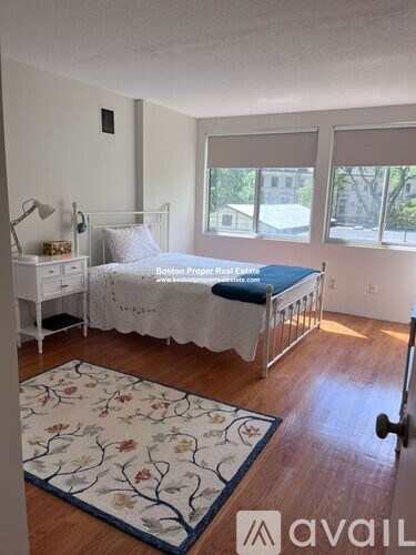 A bedroom with a bed, nightstand, and window.