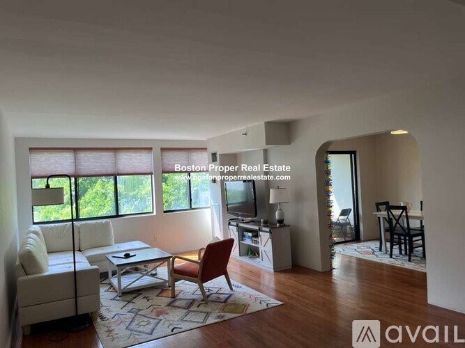 A living room with a couch, chair, and a rug.