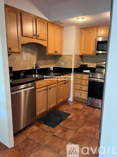 A kitchen with wooden cabinets and a tile floor.