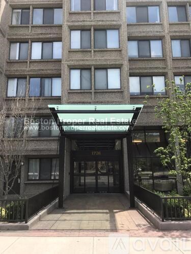 The front of a building with a green awning and a sign that says Boston Proper Real Estate.