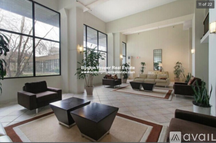 A living room with a large window and a view of trees outside.