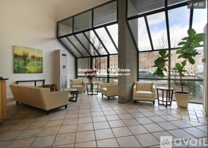 A spacious living room with a large window and furniture.