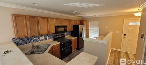 A kitchen with wooden cabinets and black appliances.
