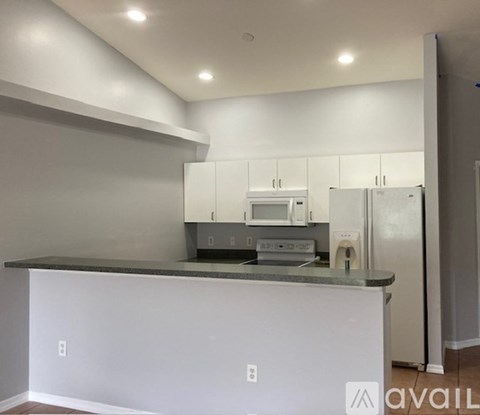 A kitchen with white cabinets and a white island.