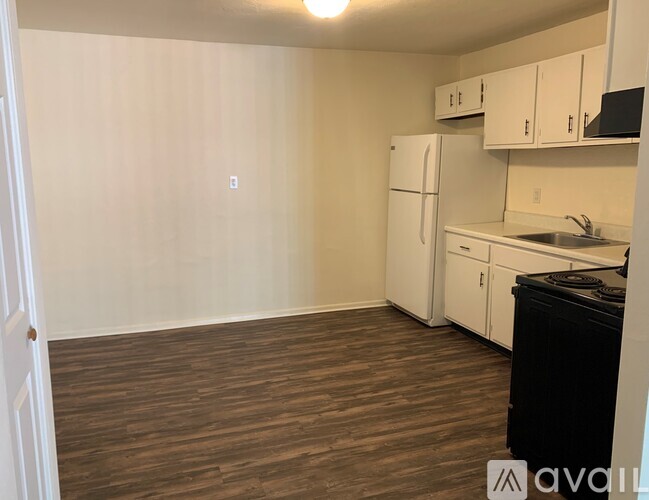 A kitchen with white cabinets and a black dishwasher.