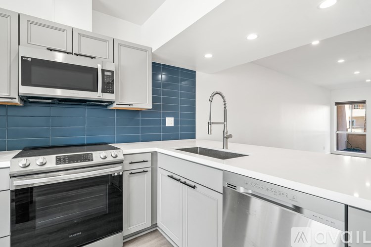 A modern kitchen with white cabinets and a stainless steel dishwasher.