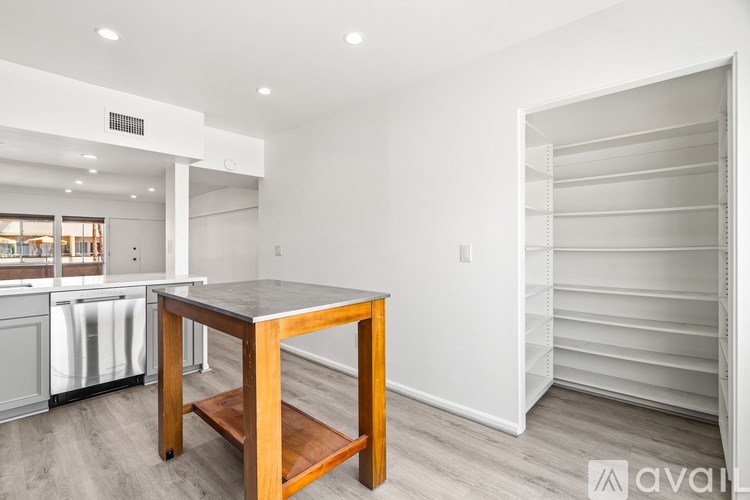 A kitchen with a table and a refrigerator.