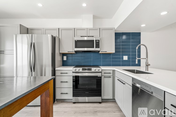 A modern kitchen with stainless steel appliances and white cabinets.