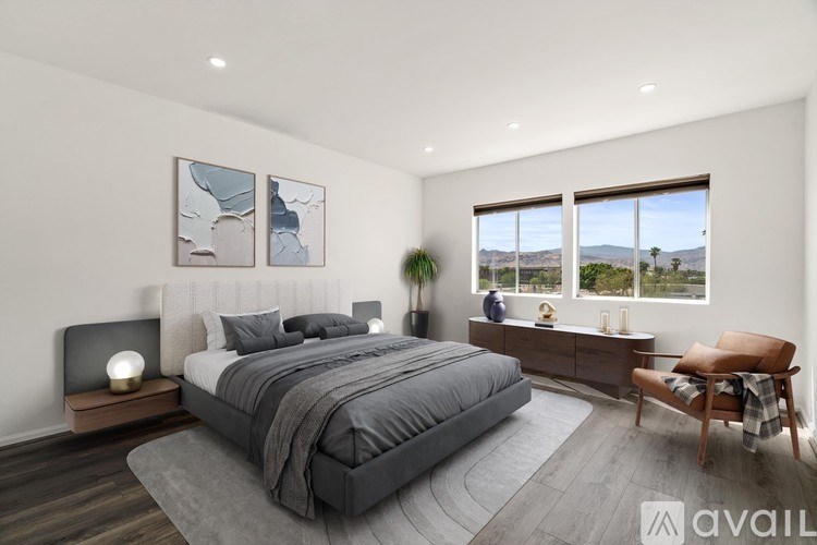A bedroom with a large bed and a view of the outdoors through the window.