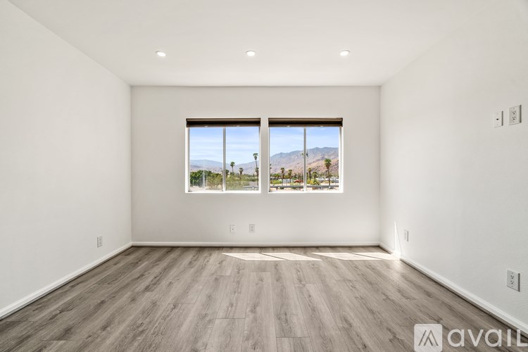 A spacious room with a large window overlooking a landscape.