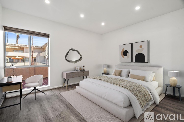 A bedroom with a large bed, a desk, and a chair.