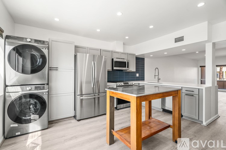 A modern kitchen with stainless steel appliances and a wooden island.