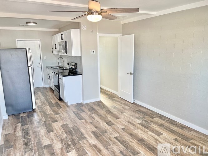 A kitchen with a refrigerator, microwave, and oven.