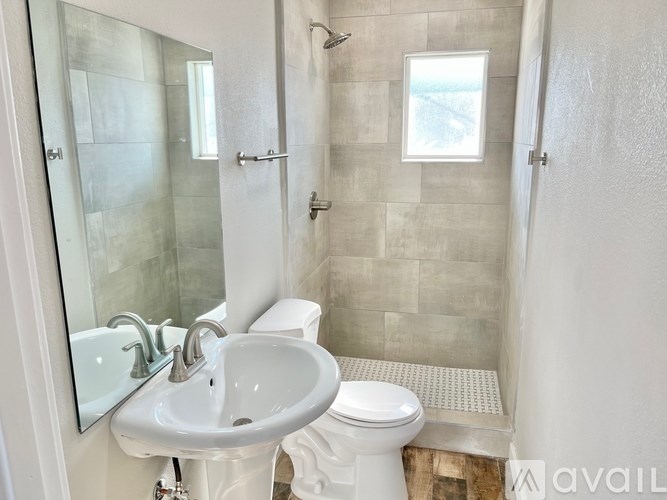 A bathroom with a white sink and toilet.