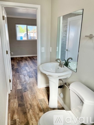 A bathroom with a white sink and toilet.