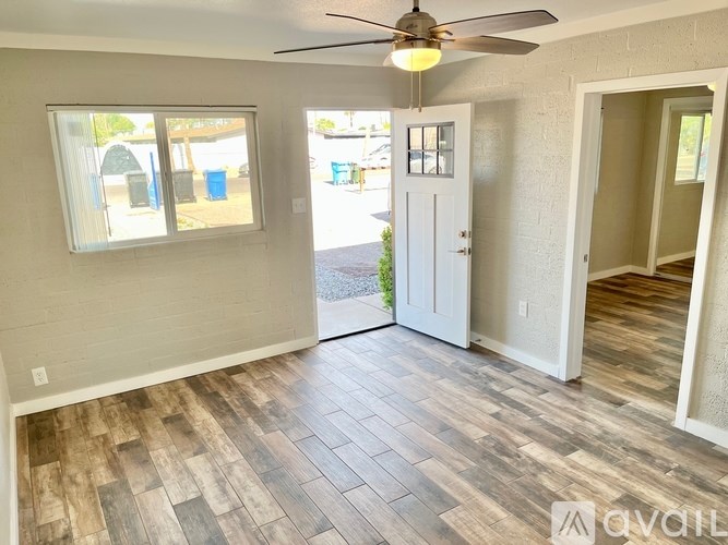 A room with a ceiling fan and a door leading outside.
