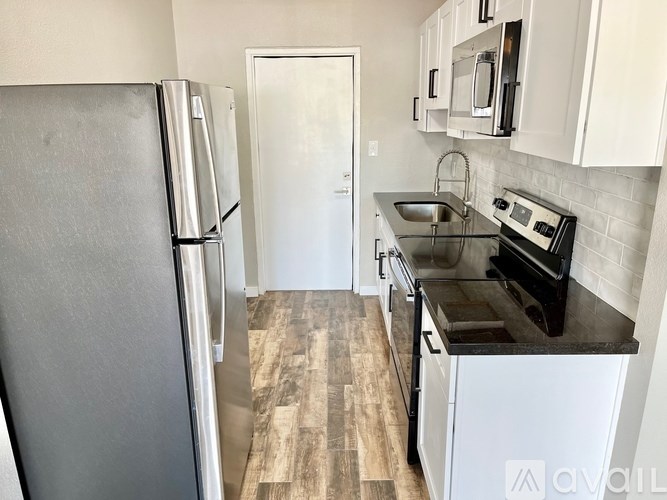A kitchen with a refrigerator, oven, and microwave.