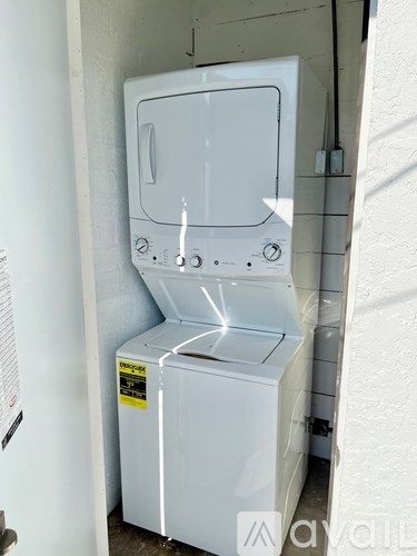 A white washing machine is sitting in a small space.