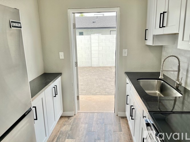A kitchen with white cabinets and a black countertop.