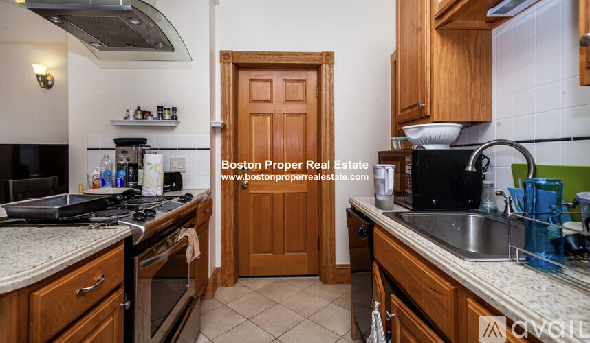 A kitchen with wooden cabinets and a tiled floor.