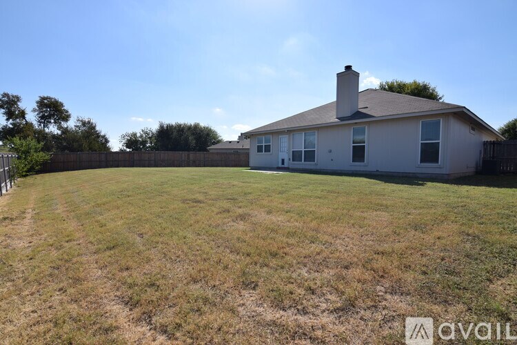 A house with a fence and a yard is available for sale.