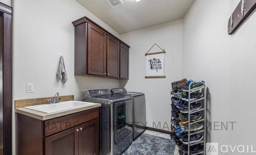 A kitchen with brown cabinets and a white sink.