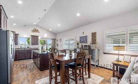 A kitchen with a dining table and chairs in the middle of the room.