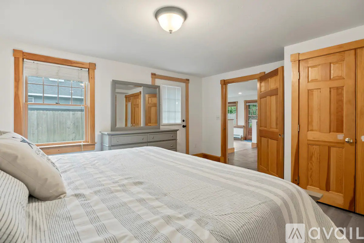 A bedroom with a large bed and wooden furniture.