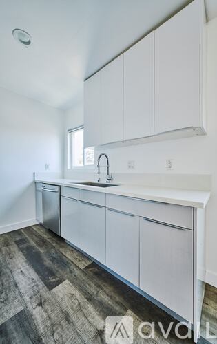 A kitchen with white cabinets and a sink.