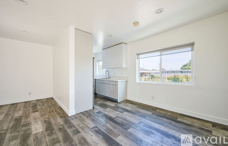 A spacious room with a kitchenette and a large window.