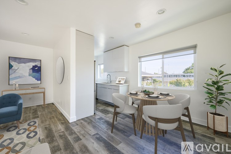 A dining room with a white table and chairs.