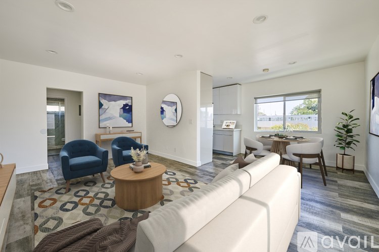 A living room with a white couch, blue chairs, and a wooden coffee table.