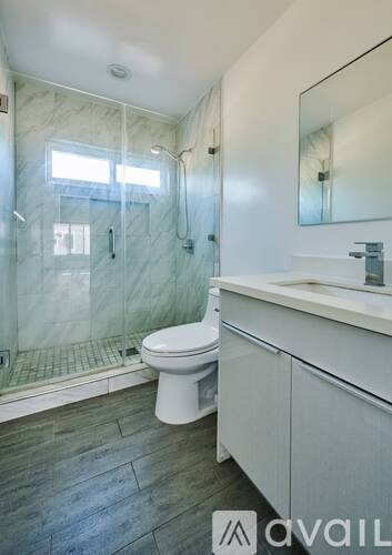 A bathroom with a toilet, sink, and walk-in shower.