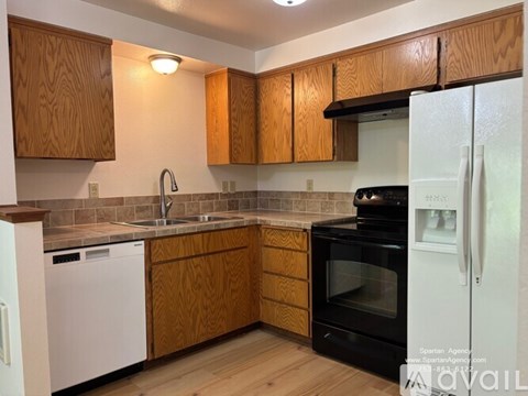 A kitchen with wooden cabinets and a black oven.