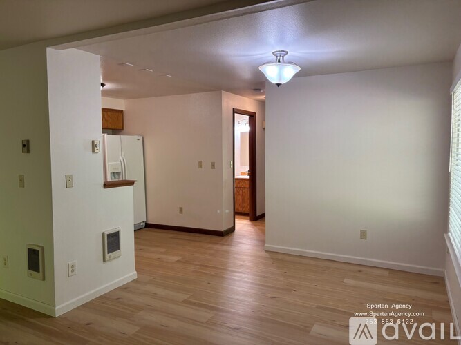 A room with a white wall and a wooden floor.