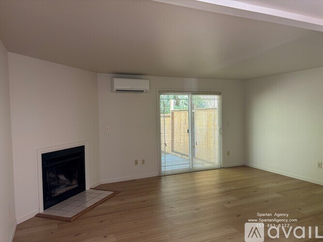 A spartan room with a fireplace and sliding glass doors.