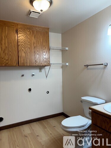 A bathroom with a toilet, wooden cabinets, and a towel bar.