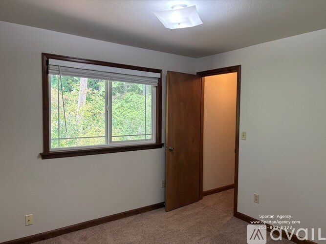 A room with a window and a door is available for rent.