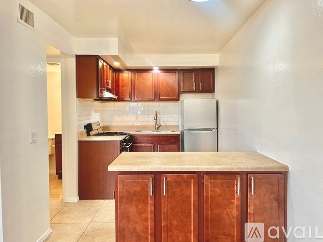 A kitchen with brown cabinets and a white refrigerator.