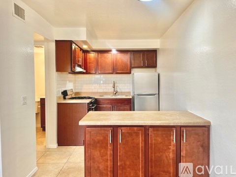 A kitchen with brown cabinets and a white refrigerator.