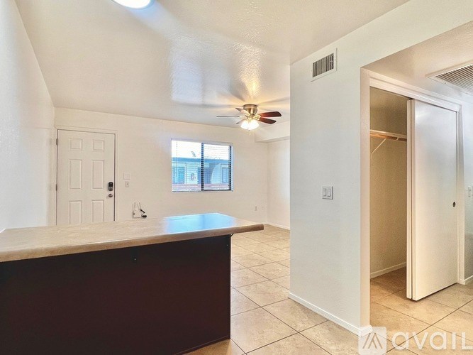 A room with a ceiling fan and a window.