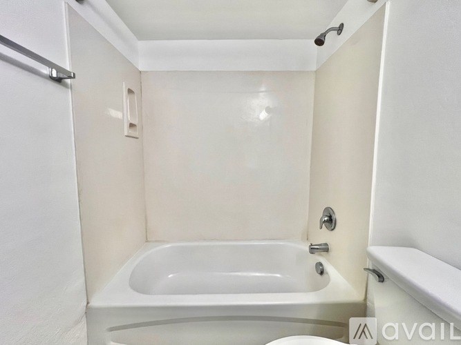 A white bathroom with a bathtub and toilet.