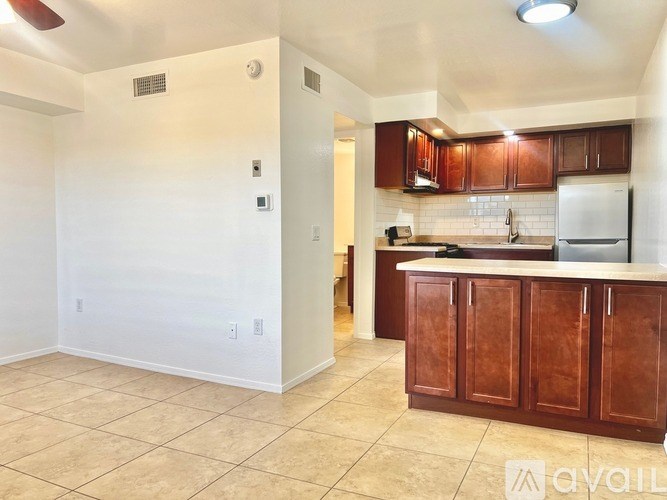 A kitchen with brown cabinets and a white refrigerator.