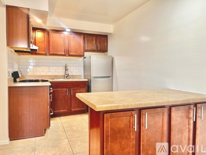 A kitchen with wooden cabinets and a white refrigerator.