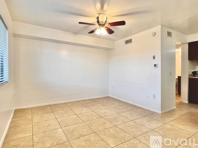 A room with a ceiling fan and tile flooring.