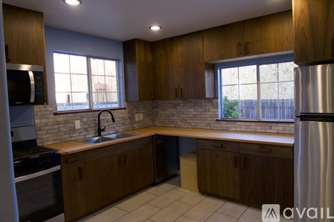 A kitchen with wooden cabinets and a brick backsplash.