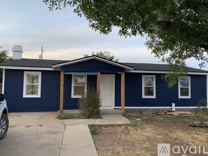 A blue house with a white door and windows.