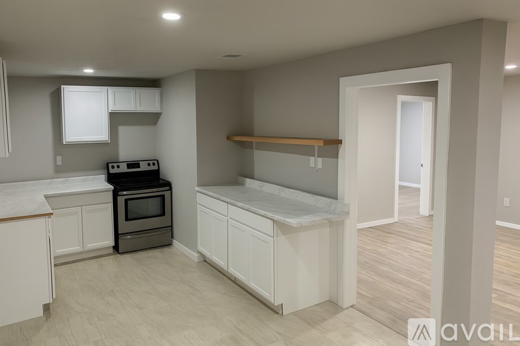 A kitchen with white cabinets and a black stove top oven.