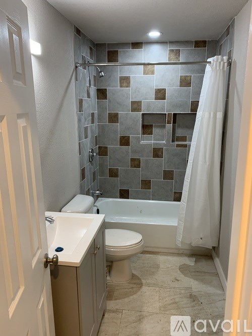 A bathroom with a tiled shower and a white toilet.