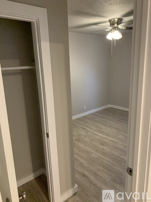 A room with a white door and a ceiling fan.